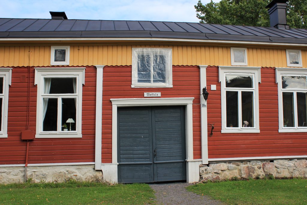 Kuvassa punakeltainen puutalo ja sen sininen kunnostettu vanhanaikainen ovi. Oven yläpuolella kyltti Mattila.