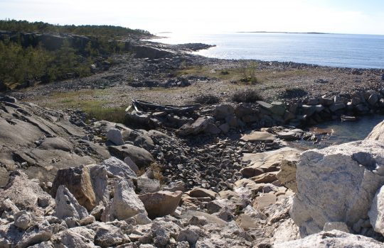 Kuvassa on louhittua kalliota, joka laskee merenrantaan.