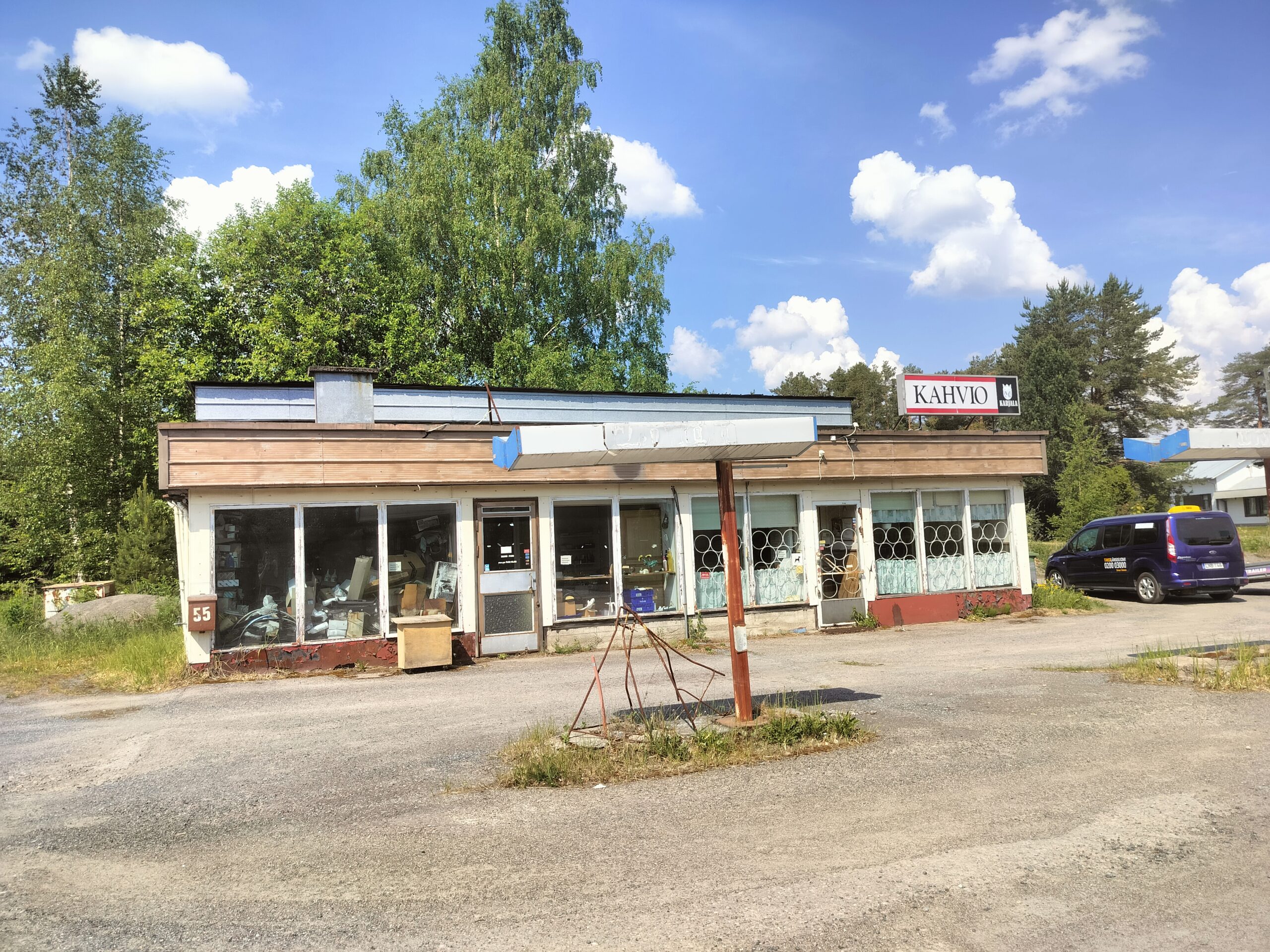 Valkoinen yksikerroksinen laatikkomainen rakennus, jonka etuseinä on isoja ikkunoita. Tasakatto.